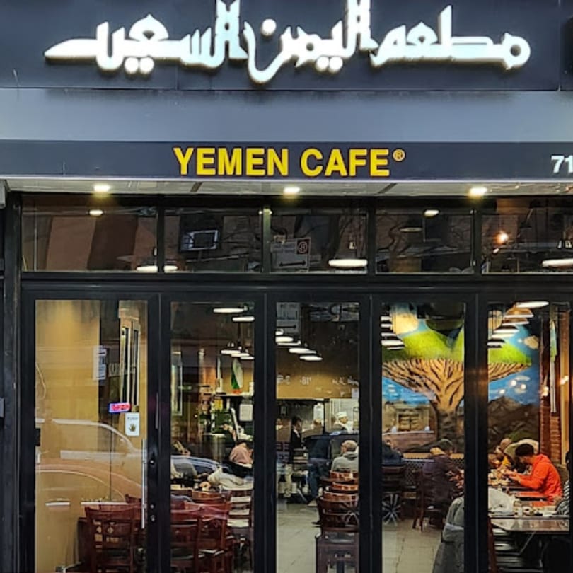 Exterior of Yemen Cafe & Restaurant with its sign and customers visible through the windows.