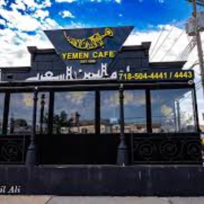 Exterior of Yemen Cafe & Restaurant with a black facade, large windows, and a prominent sign.