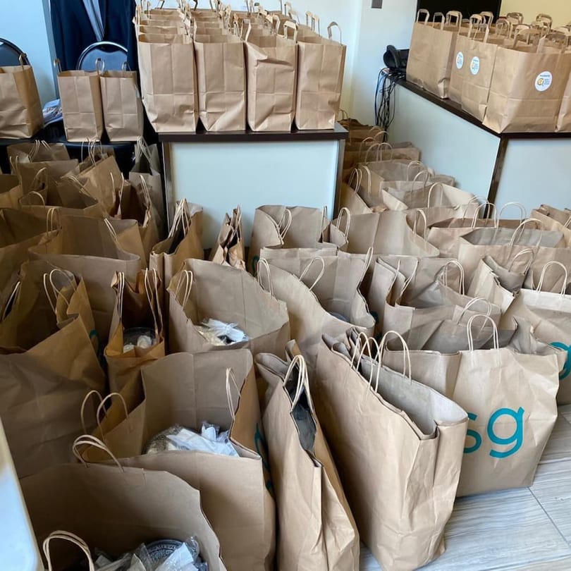 Numerous brown paper bags, some with logos, filled with takeout orders from Yemen Cafe & Restaurant.