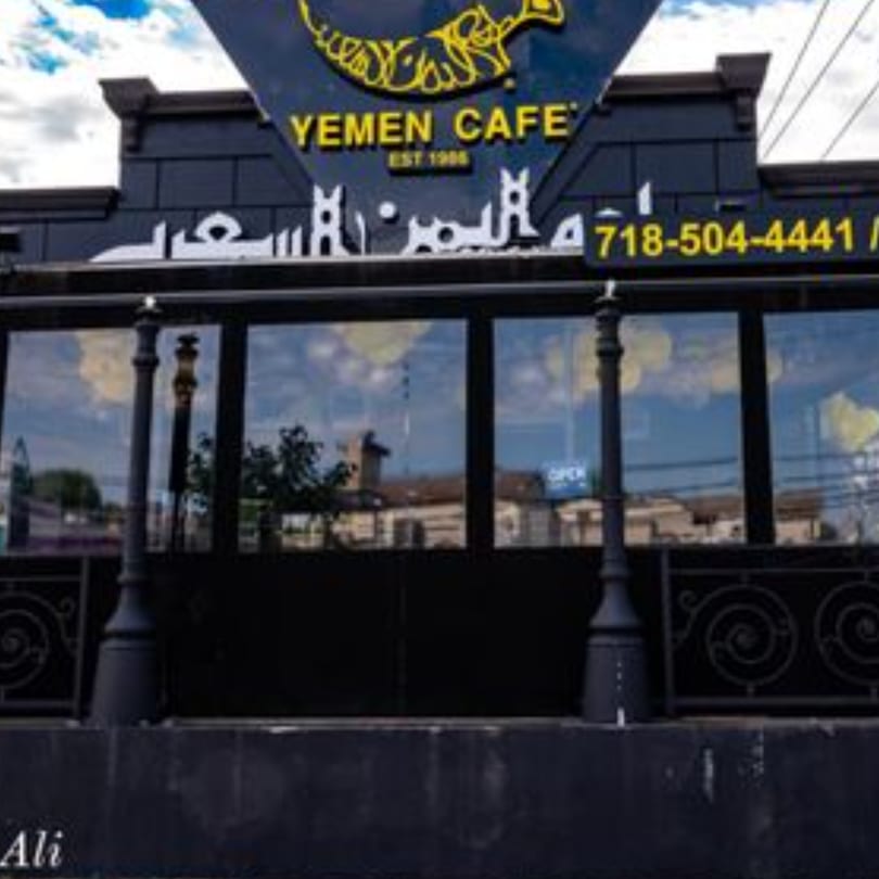 Exterior of Yemen Cafe & Restaurant with a black facade, large windows, and a prominent sign.