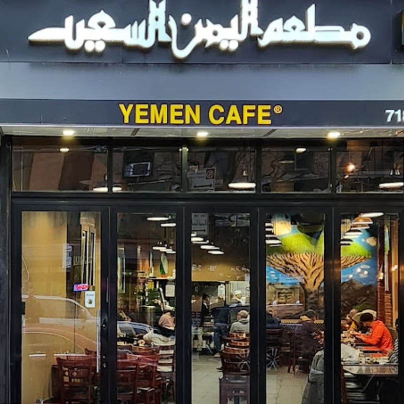 Exterior view of Yemen Cafe & Restaurant with its sign and patrons visible through the windows.