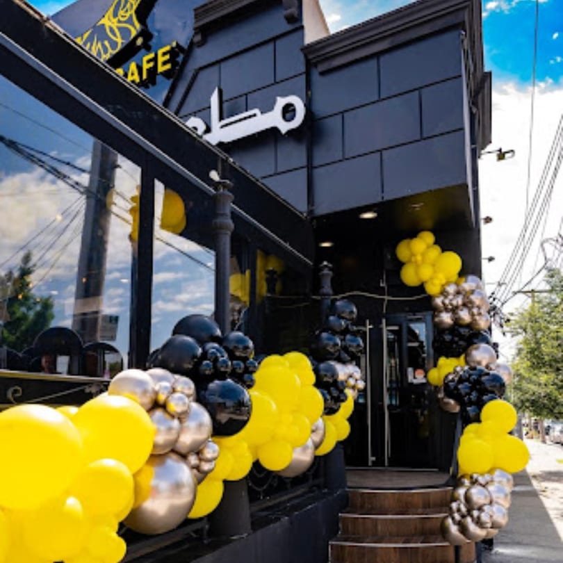 Exterior of Yemen Cafe & Restaurant, adorned with black, yellow, and silver balloons for an event.
